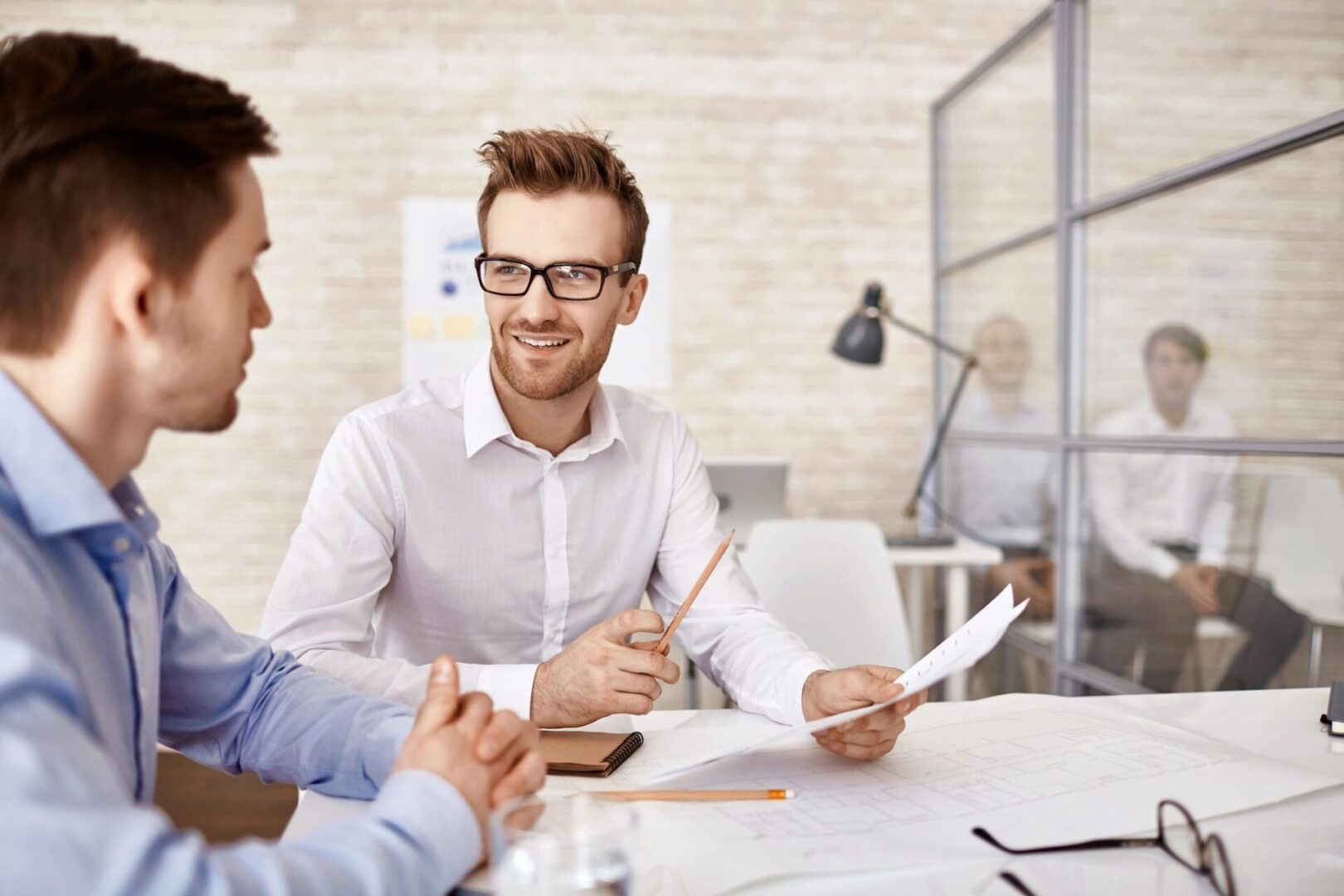 Two colleagues discussing in a modern office.